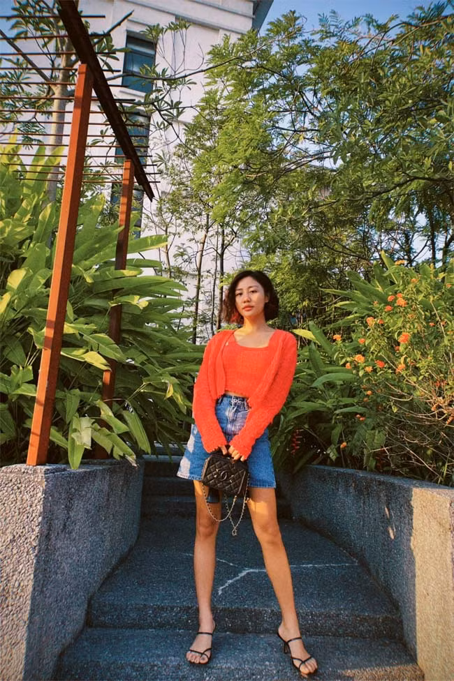 Chân váy jeans chữ A, áo len mỏng màu cam mang lại cho Văn Mai Hương một tổng thể thật năng động, trẻ trung.
