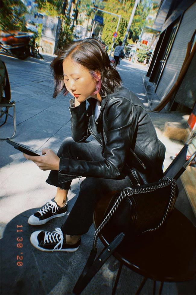 Áo da đen, quần jeans đen, giày vải và túi cùng màu trang phục, giọng ca sinh năm 1994 trẻ trung dạo phố.