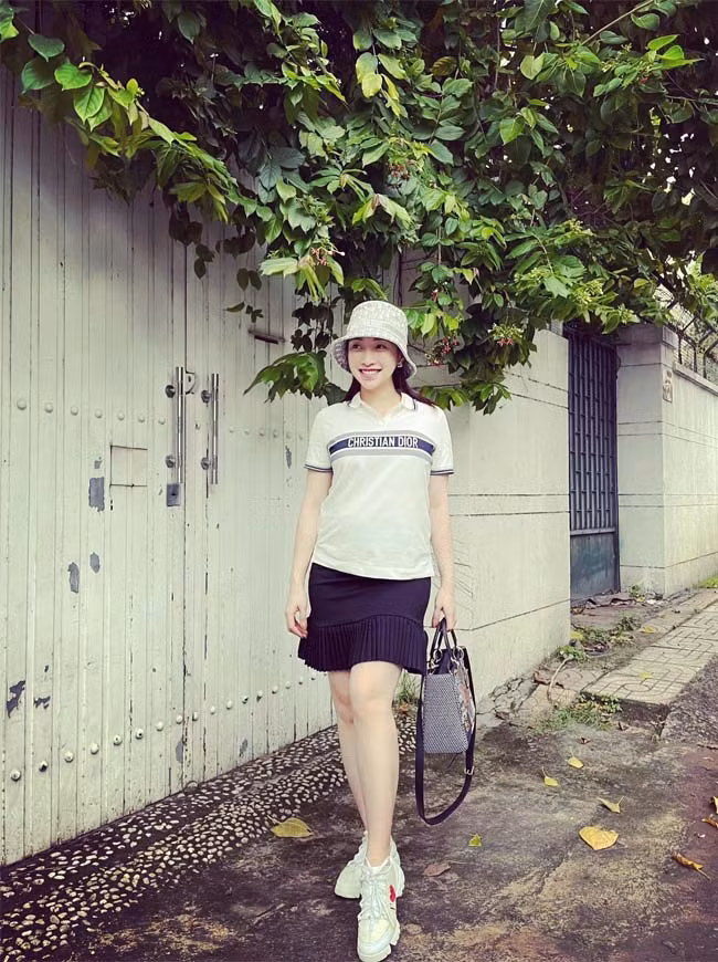 Áo phông trắng, chân váy ngắn hơi xoè, giày thể thao, nếu không có chiếc bụng bầu thì trông Lý Thuỳ Chang trẻ trung không khác gì nữ sinh trung học.