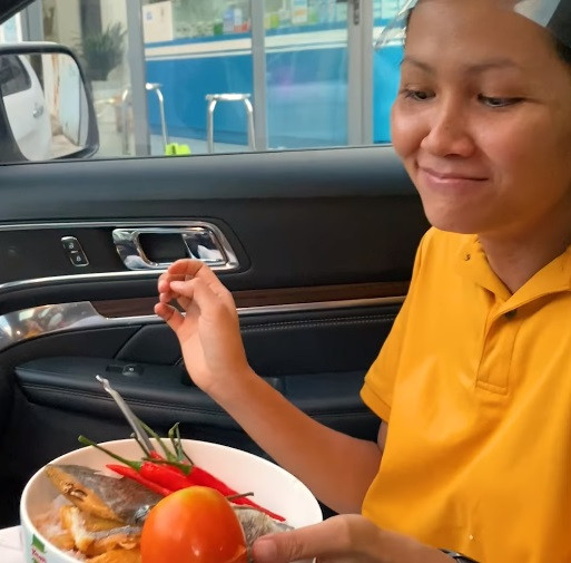 Bữa ăn vội trên xe của người đẹp Ê-đê trước khi bắt đầu hành trình tiếp theo.