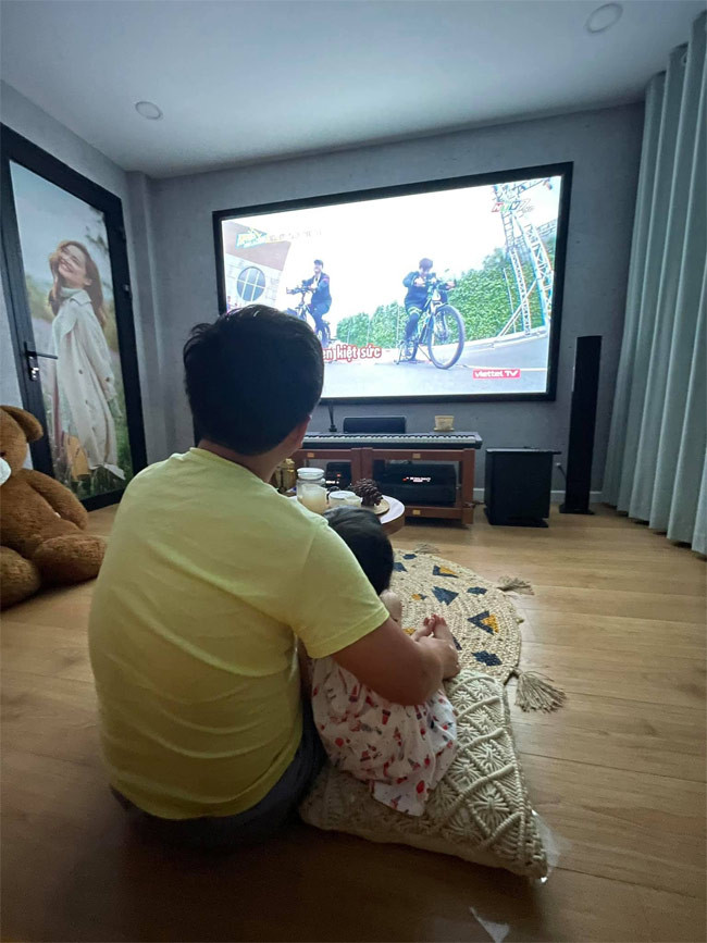 Hai cha con tình cảm ngồi xem tivi với nhau.