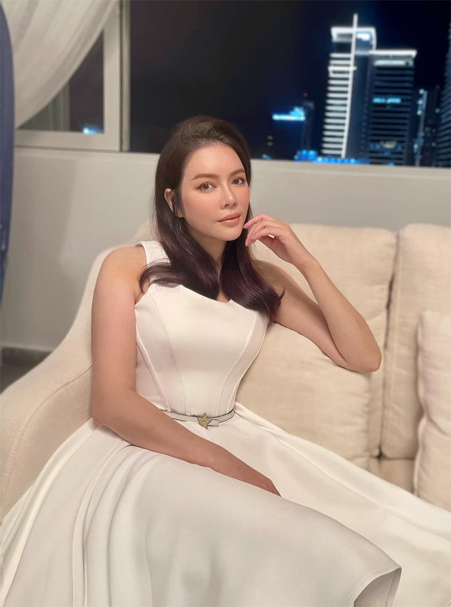 Lý Nhã Kỳ diện chiếc váy xòe màu trắng đơn giản khoe eo thon rồi chụp một kiểu ảnh trong phòng khách làm kỷ niệm.