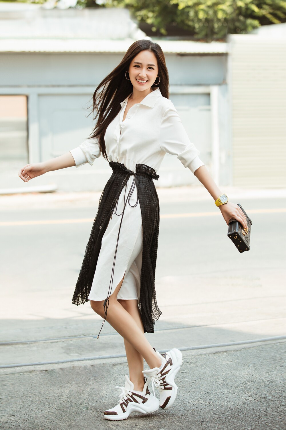 Phụ kiện trang sức được "chị đại làng hoa hậu" lựa chọn là đồng hồ vàng, khuyên tai tròn và clutch thời trang.