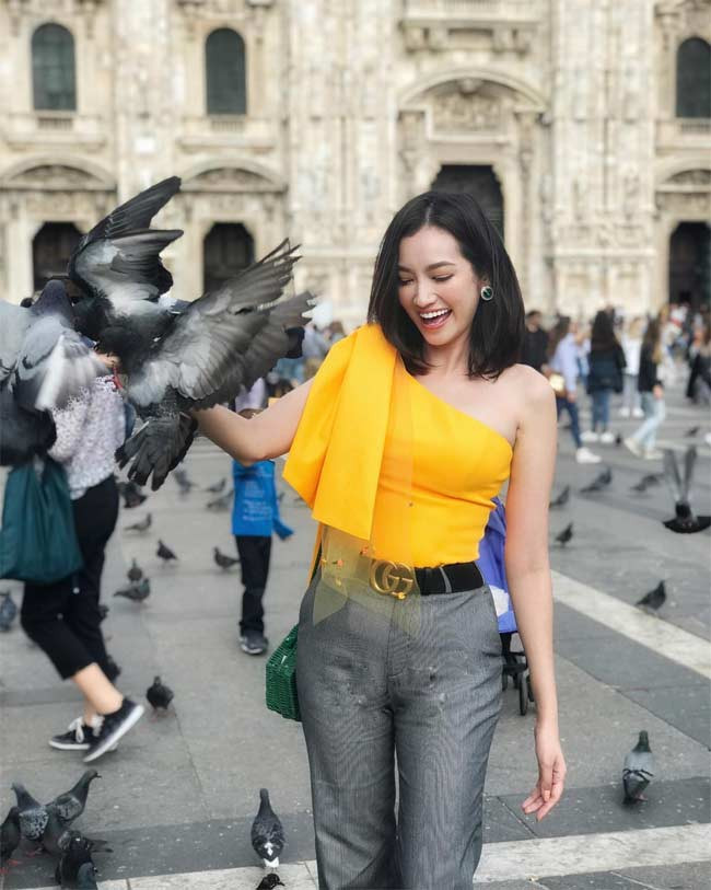 Áo lệch vai với điểm nhấn là dải nơ trên vai kết hợp với quần âu màu ghi, Trúc Diễm tự tin trên phố với set đồ thanh lịch.