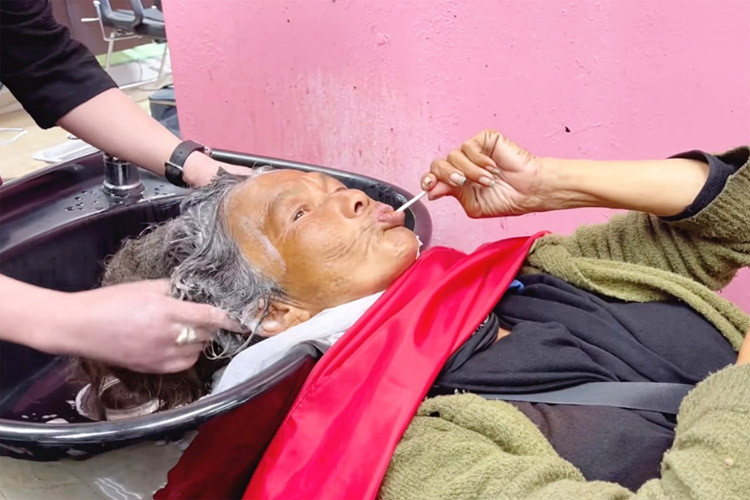 Thúy Nga đã khéo léo dỗ Kim Ngân đi gội đầu, và chủ tiệm phải gội đến 7 lần dầu gội thì tóc của Kim Ngân mới có bọt. Đây cũng là lần đầu nữ ca sĩ chấp nhận để người khác rửa mặt, cắt móng tay cho mình. (Ảnh: Thúy Nga Channel)