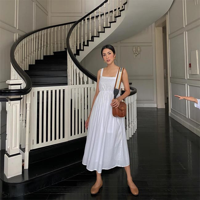 Nàng ngọc nữ xuống phố với trang phục váy trắng hai dây cùng phụ kiện là túi và giày màu nâu.