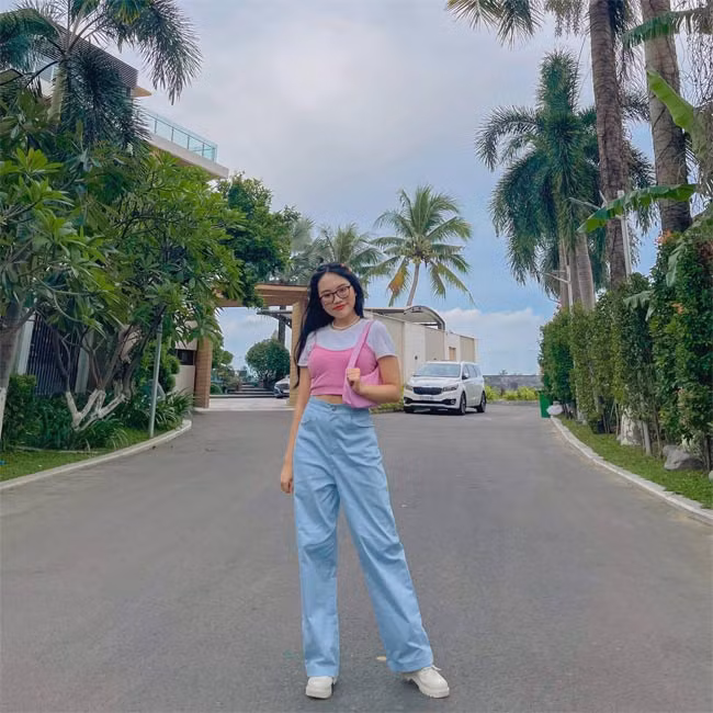 Nhìn Phương Mỹ Chi rất năng động với set đồ: quần jeans ống suông cạp cao, áo crop top kết hợp với áo hai dây bên ngoài.