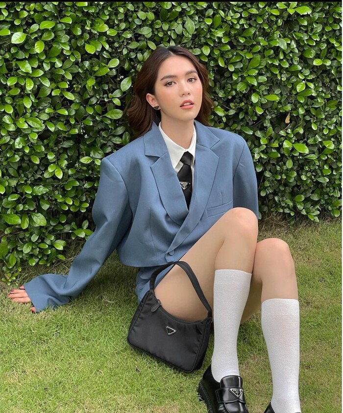 Mỹ nhân gốc Trà Vinh diện tất trắng và giày âu cùng kiểu túi vintage nhỏ gọn của nhà mốt Prada.