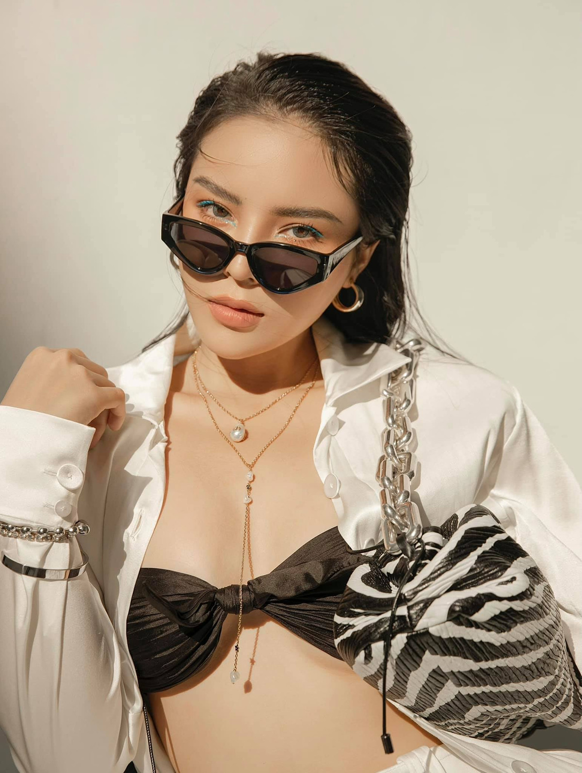 Diện set đồ trắng tới từ NTK Công Trí, nàng hậu phanh hết cúc áo nhằm khoe trọn vòng một đồ sộ bị o ép dưới lớp bra màu đen nổi bật.