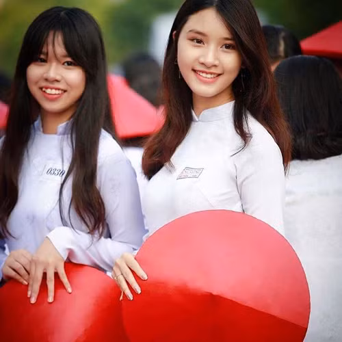 Giữa hàng ngàn nữ sinh mặc áo dài, xếp hàng đều tăm tắp, cô gái vẫn nổi bần bật nhờ nụ cười hút hồn. Ngay cả chủ nhân của chùm ảnh ấn tượng này cũng phải thừa nhận, đã bị vẻ đẹp dịu dàng, nền nã ấy cuốn hút nên mới ưu ái ghi lại nhiều khoảnh khắc đến thế.