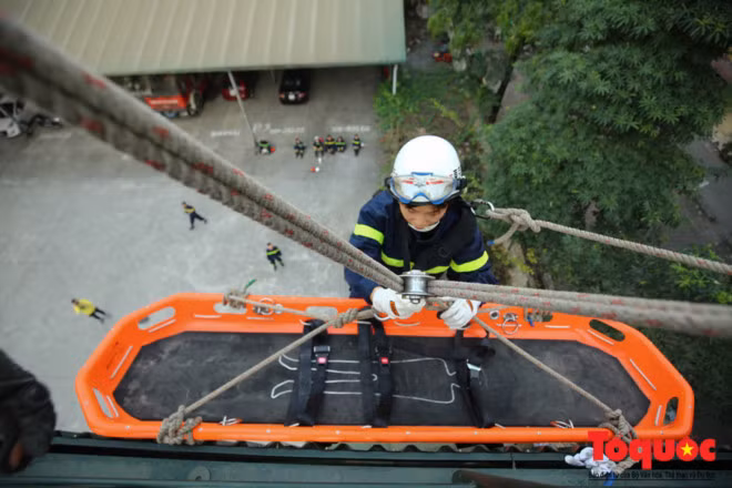 Đại úy Nguyễn Thị Ngọc Lan thực hiện nhiệm vụ đưa nạn nhân theo cáng từ nhà cao tầng xuống đất.