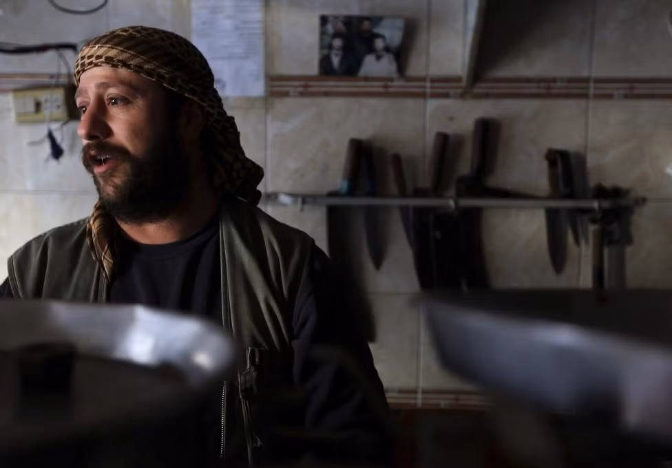 Người đàn ông làm việc trong một cửa hàng thịt nướng ở Damascus.