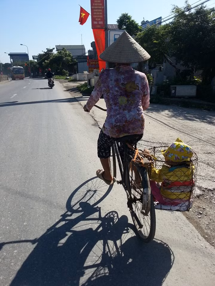 Còn đây là bức ảnh chụp vào sáng nay tại quốc lộ 21B, đoạn qua xã Vạn Thái, Ứng Hòa, Hà Nội, dưới cái nắng 37°C. Bức ảnh được đặt tên "Em đi uống Vitamin A nhân ngày Quốc tế Thiếu nhi", bởi sáng nay 1/6, sở Y-tế Hà Nội chính thức triển khai "Ngày vi chất dinh dưỡng" năm 2016, trẻ em dưới 5 tuổi được uống Vitamin A miễn phí tại tất cả các cơ sở Y tế xã, phường trên toàn thành phố. Chiếc xe thồ với giỏ hàng nơi đặt đứa bé phía sau khiến người xem ảnh cảm nhận ngay được nỗi vất vả của cuộc sống nơi miền quê này. Dù vất vả, khó khăn nhưng trong ngày Quốc tế Thiếu nhi, những em bé vẫn có quyền được tận hưởng niềm vui, được đón nhận những món quà và được chăm sóc, quan tâm với vòng tay tràn ngập yêu thương của gia đình, xã hội. Ảnh: Minh Bái.