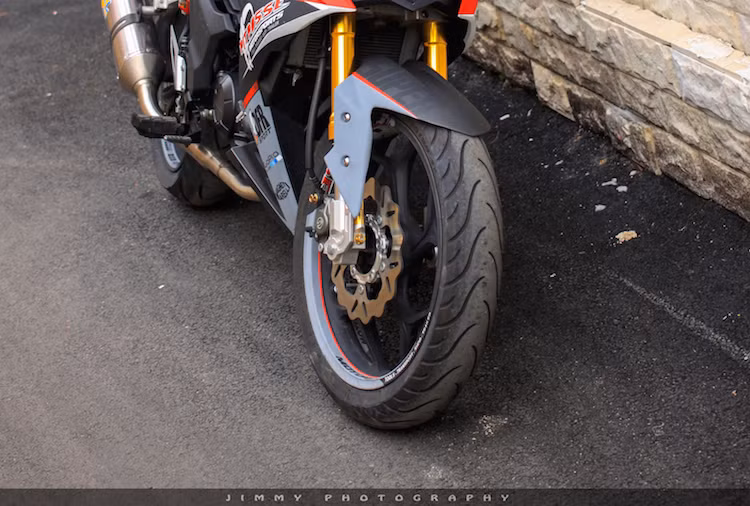 "Dàn chân" của Winner cũng được chủ nhân để mắt với mâm trước thay bằng loại bản lớn 5 cánh kép của hãng Asio, nằm giữa cặp phuộc USD. Hệ thống phanh cũng được nâng cấp toàn diện với đĩa Galfer và heo Brembo 2 pis đối xứng.