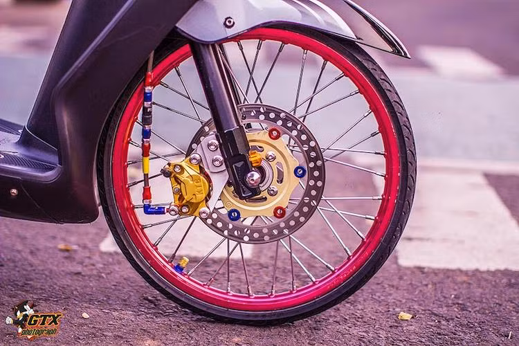 Bắt đầu từ phía trước, vành nan 14 inch của phiên bản Mio Amore đã được thay bằng niềng nhôm bản mỏng 17 inch, kết hợp cùng với lốp mỏng của xe đua drag. Bên cạnh đó, hệ thống phanh đùm của Amore nay đã được nâng lên phanh đĩa với heo KTC kiểu dáng giống heo Brembo 2 pis đối xứng và dây dầu Morin.