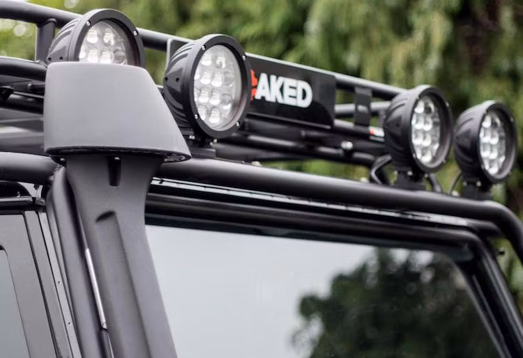 Giống như nhiều mẫu xe offroad chuyên nghiệp khác, chiếc Defender bản độ Spectre cũng có ống thở, cùng với dàn đèn chiếu sáng LED tăng cường được đặt ở trên nóc xe.