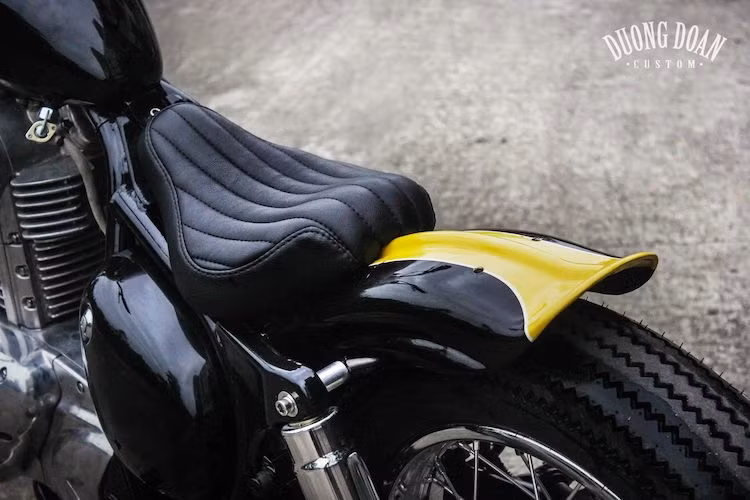 Theo đúng phong cách bobber, phần dè sau đã được cắt gọn lại, tiếp tục sơn với tông màu đen vàng và uốn cong ở phía cuối. Phía trên là một chiếc yên solo hẹp, cong đều và chần chỉ dọc đẹp mắt.