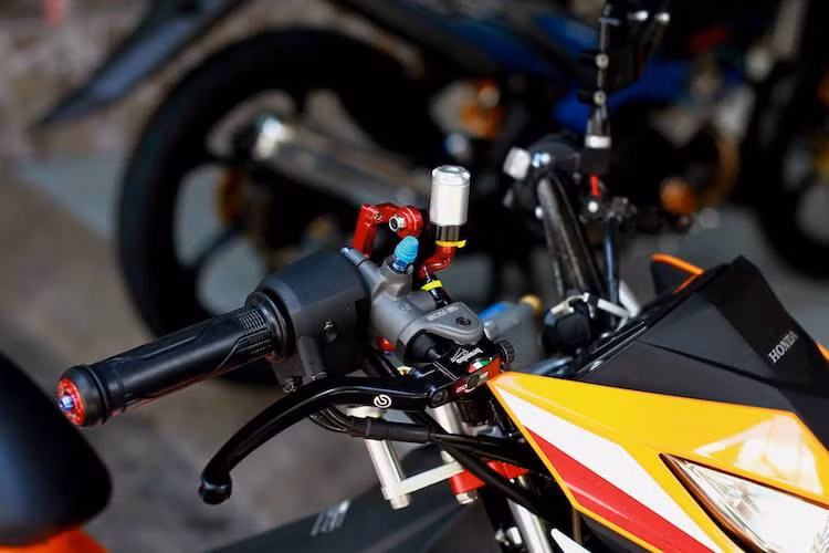 Ở phía trên tay lái, phía bên trái là cùm phanh Brembo RCS 19, trong khi cùm côn do hãng CRG của Mỹ cung cấp. Cuối 2 đầu tay lái là cặp gù đỏ nổi bật của CNC Racing, được sản xuất tại Ý.