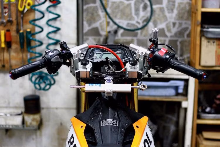 Kết nối trực tiếp với phuộc Ohlins là cặp tay lái clip-on được tạo ra bằng nhôm CNC, không chỉ chắc chắn hơn tay lái nguyên bản mà còn đem tới cho chiếc Sonic 150R vẻ đẹp cứng cáp và bắt mắt hơn.