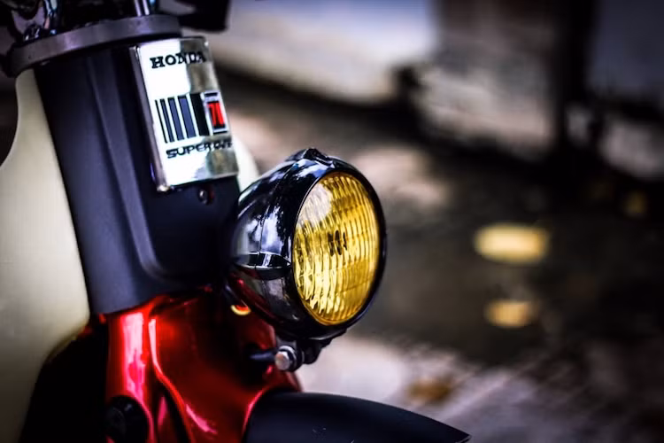 Để tạo phong cách đơn giản và cổ điển cho chiếc xe, thay vì đèn pha trên tay lái như những chiếc Cub bình thường, đèn pha của xe đã được chuyển xuống dưới. Theo đúng phong cách bobber, đèn pha của xe có dạng tròn cổ điển và không có đèn xi-nhan phía trước.