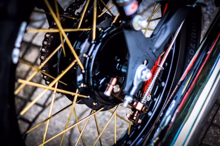 "Dàn chân" của chiếc xe cũng được nâng cấp đơn giản với moay-ơ nguyên bản của Cub, nhưng được kết hợp với bộ nan hoa màu vàng nổi bật và vành Racing Boy.