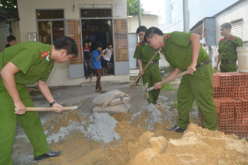 Các chiến sĩ công an quận 9, TP HCM trộn hồ để chuẩn bị xây dựng tiệm rửa xe hỗ trợ việc làm cho thanh niên sau cai nghiện tại phường Phú Hữa