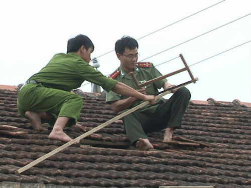 Công an giúp dân lợp mái nhà.
