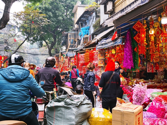 Dòng người và xe cộ len lỏi giữa những lối đi tại phố Hàng mã càng khiến không khí mua sắm Tết nơi đây trở nên nhộn nhịp, tấp nập.