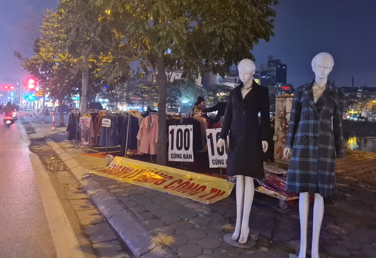 Không chỉ có thời trang hàng hiệu, nhiều sản phẩm quần áo thanh lý cũng đổ bộ vỉa hè Hà Nội với giá bán dao động từ 100 - 150 nghìn đồng/chiếc.