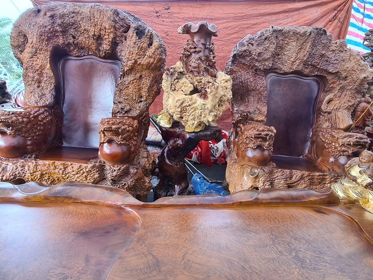 Tại mỗi bên của 4 chiếc ghế đơn và đầu của chiếc bàn dài đều được nghệ nhân đục đầu Lân, tổng cộng 9 đầu Lân.