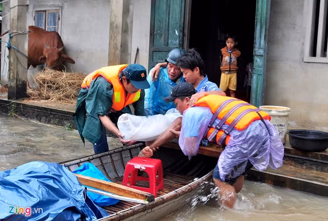 Liên tục 9 ngày qua, lũ chồng lũ liên tục tràn về gây ngập nhiều khu dân cư ở tỉnh Quảng Ngãi, Bình Định. Lực lượng dân quân, thanh niên xung kích huyện Đức Phổ giúp người dân vùng trũng thấp đến ở vùng cao an toàn. Trong ảnh là lực lượng cứu hộ của xã Phổ Ninh đưa anh Huỳnh Quang Quyền (34 tuổi, ngụ thôn An Trường) vừa gặp tai nạn giao thông, chân phải bó bột, đến trụ sở Ủy ban xã tránh lũ chiều 2/12.