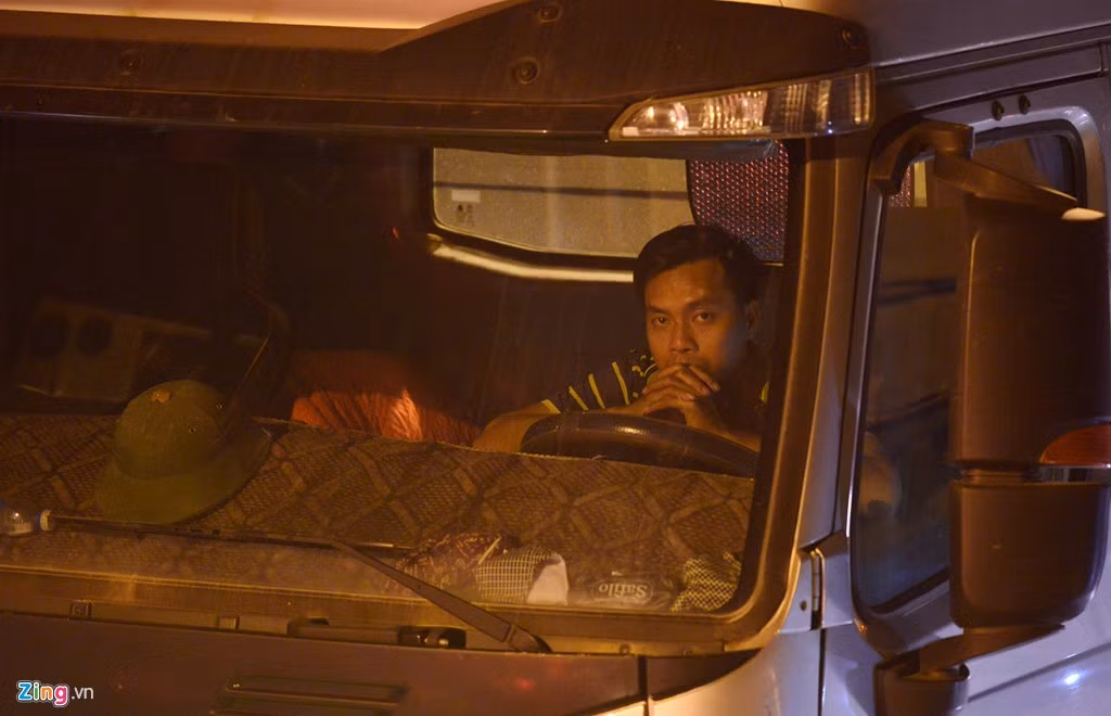 Nhiều lái xe tải sốt ruột ngồi chờ trên xe di chuyển từng mét một.