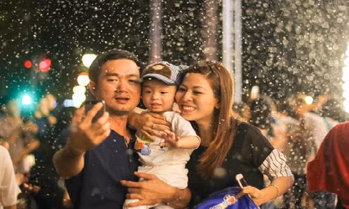 Gia đình anh Trọng tranh thủ ghi lại khoảnh khắc "tuyết" rơi giữa lòng thành phố.