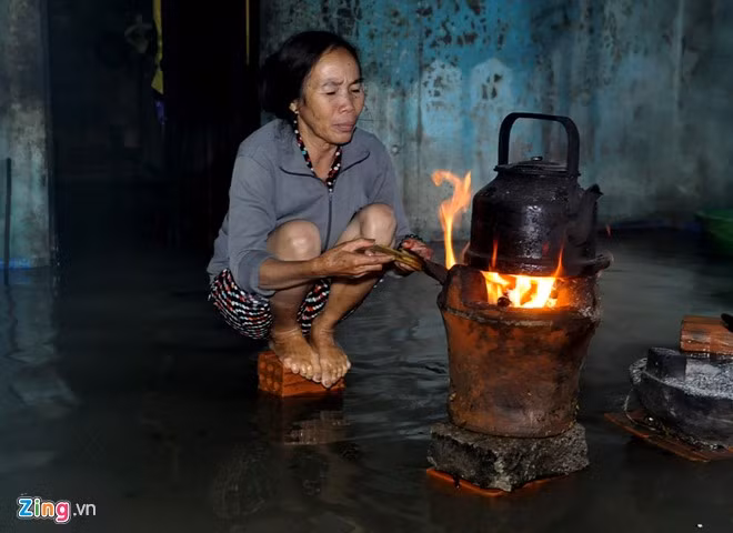 Ngày 3/12 có đến hai đợt lũ tràn vào nhà, bà Nguyễn Thị Xuân Mai (ngụ thôn An Trường, xã Phổ Ninh) lấy gạch, đá kê bếp, vừa nấu ăn vừa sưởi ấm trên nền nhà ngập lũ.