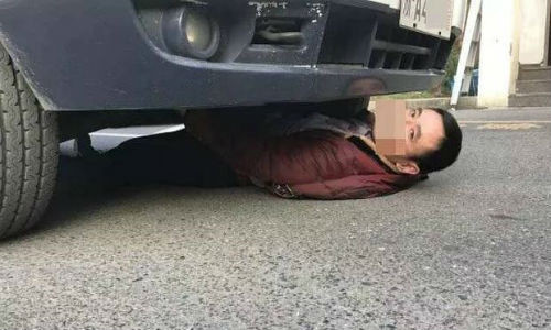 Người đàn ông 'cố thủ' trong gầm xe.