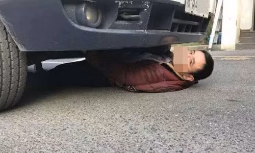 Người đàn ông 'cố thủ' trong gầm xe.