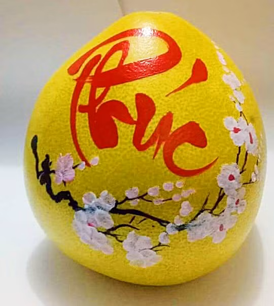 Hai màu chủ đạo khi vẽ thư pháp lên bưởi là màu đỏ và màu hồng. Ảnh: FB Huyền Béo