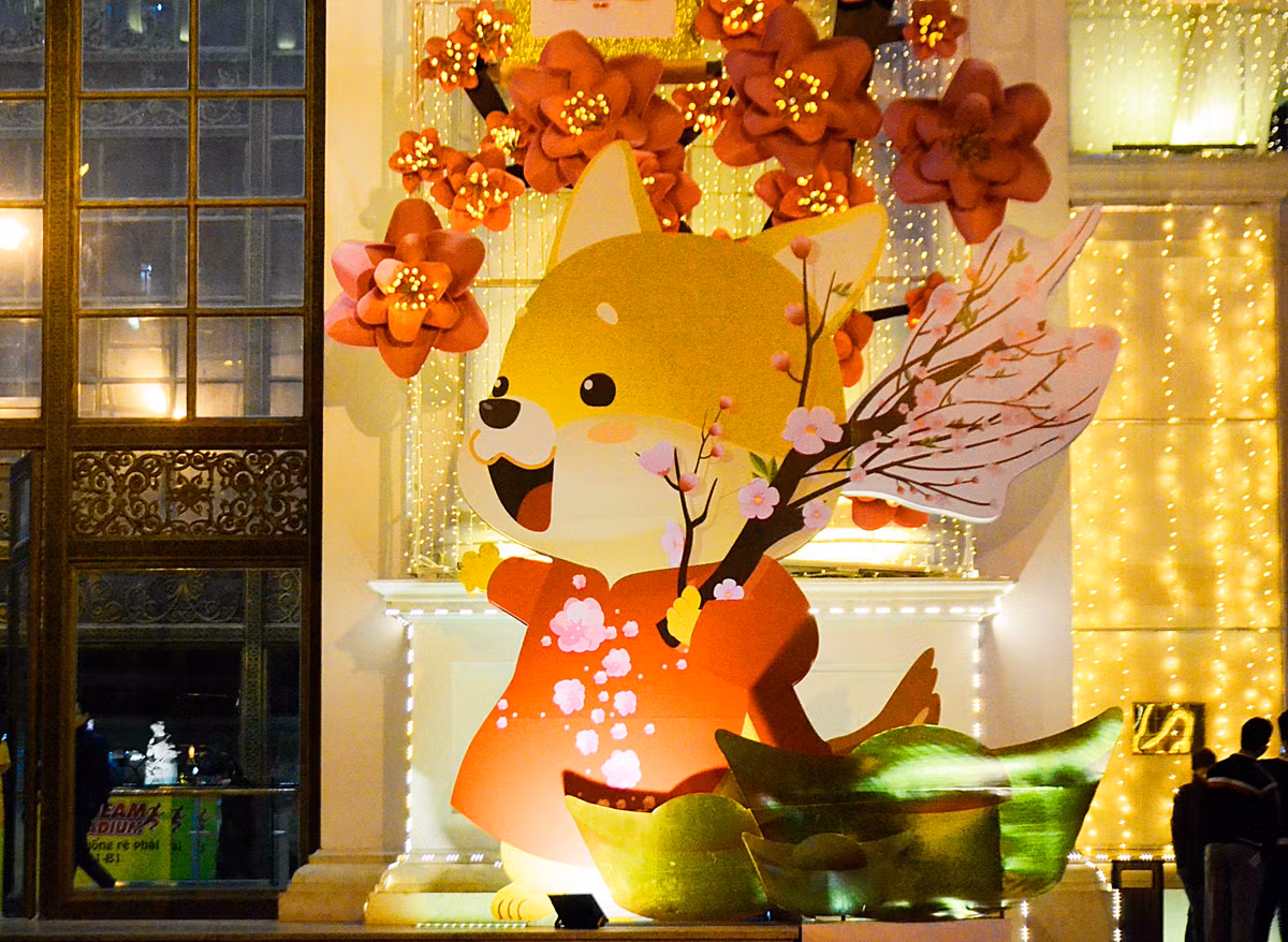 Những chú chó linh vật của năm ngộ nghĩnh cầm cành đào vui vẻ đón Tết 2018 được khách hàng đặc biệt yêu thích.