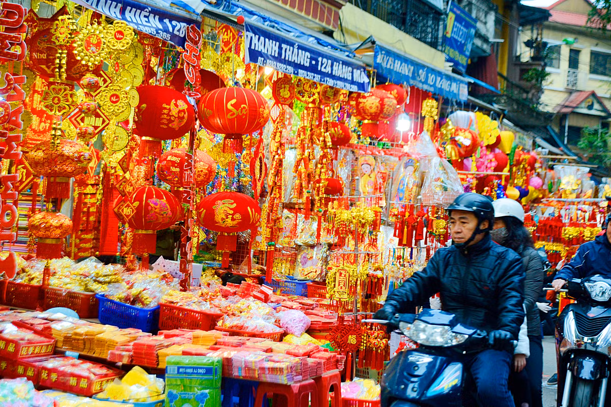 Trên khu phố Hàng Mã những ngày này, đi đến đâu cũng thấy những chuỗi đèn lồng đỏ đỏ rực, chuỗi tiền vàng, hoa giấy xanh tím treo đầy hai bên đường.