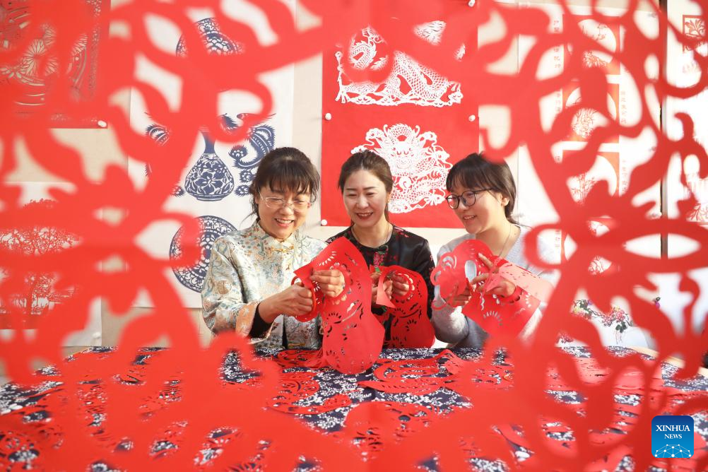 Ge Ying (trái), một nghệ nhân cắt giấy, đang hướng dẫn mọi người làm các tác phẩm cắt giấy chào mừng Năm Tỵ tại thành phố Đường Sơn, tỉnh Hà Bắc, ngày 22/1.