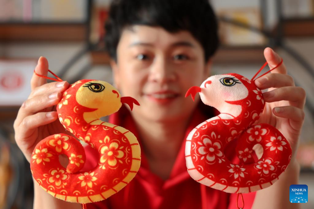 Một nghệ nhân trưng bày đồ chơi rắn làm bằng vải ở Tân Châu, tỉnh Sơn Đông, miền đông Trung Quốc, ngày 21/1.