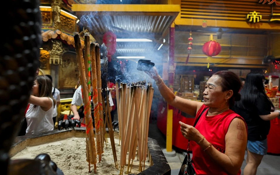 Người phụ nữ đi lễ ở chùa Leong Nam, Singapore, vào ngày đầu tiên của Tết Nguyên đán Ất Tỵ (29/1). Ảnh: Reuters.