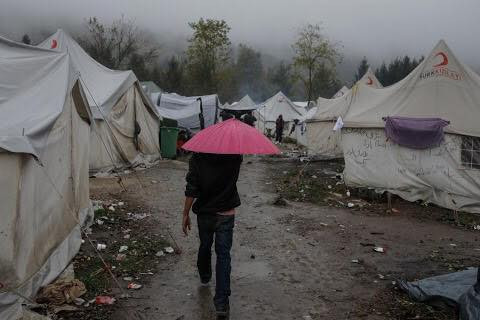 Một người nhập cư đang đi qua những túp lều trong trại Vucjak. Khu trại tạm bợ này được xây dựng trên nền một bãi xử lý rác thải cũ.