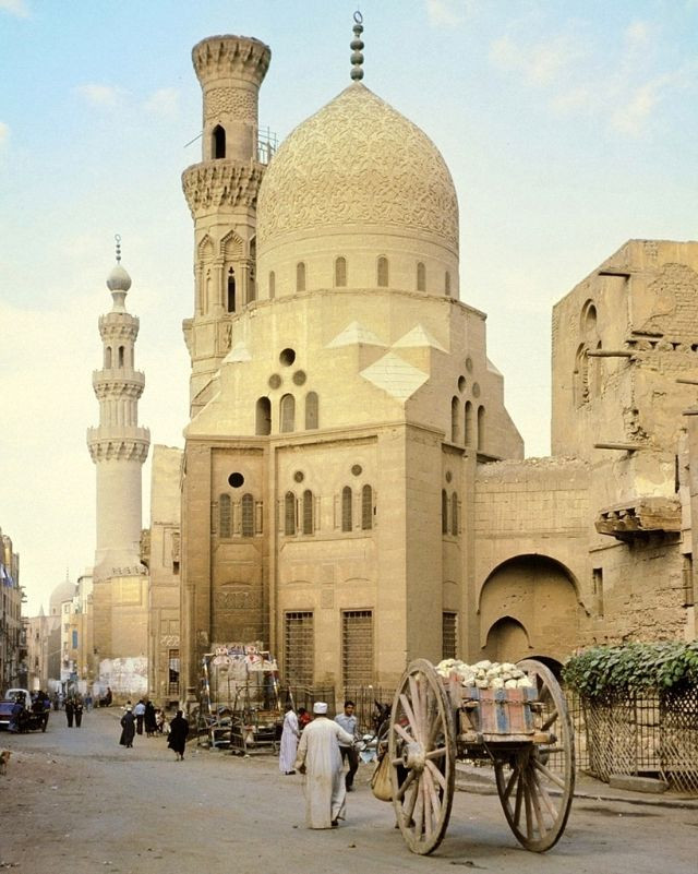 Một chiếc xe lừa với bánh xe lớn đặc trưng phía trước nhà thờ Hồi giáo ở Cairo.