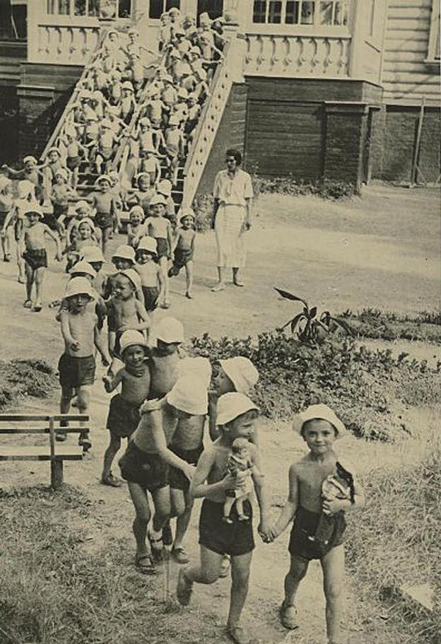 Tại một trường mẫu giáo những năm 1930. Vào thời gian đầu của nhà nước Liên Xô, phụ nữ đã tham gia tích cực vào công cuộc lao động để xây dựng đất nước, vì vậy thời gian nghỉ hậu sản của họ khá ngắn - chỉ khoảng 6 tháng. Vì lẽ đó, trẻ em được gửi tới các trường mầm non từ khá sớm, có thể là 2 - 3 tháng tuổi. Tới những năm 1970, thời gian nghỉ hậu sản được kéo dài lên 18 tháng.