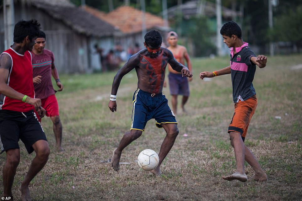 Dù chỉ chơi đá bóng, người thanh niên này vẫn không quên sơn lên mình một lớp sơn màu đỏ - một phong tục lâu đời của bộ lạc Tembe trước khi bước vào mỗi trận chiến. 