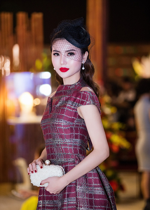Người đẹp diện váy dạ hội của NTK Phương My, đội mũ ren lưới, đeo bông tai ngọc trai và mang ví cầm tay. 