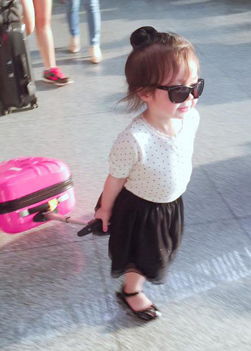 Bé Mộc Trà còn tự tin kéo chiếc vali màu hồng dễ thương khiến nhiều người thích thú. (Ảnh: Facebook Elly Trần)