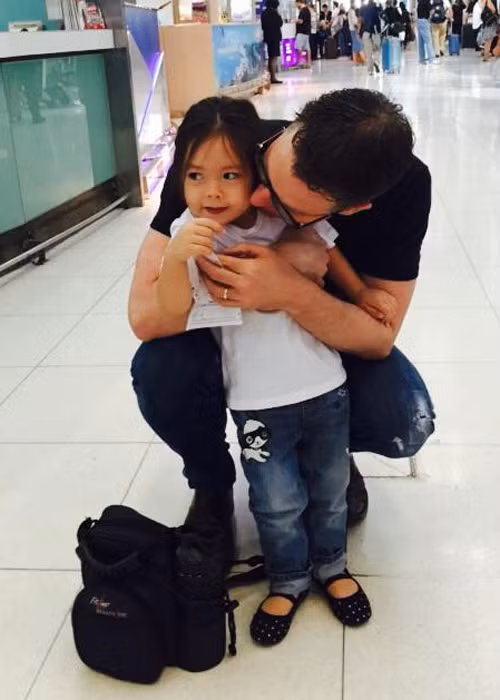 Bé Sol diện áo thun trắng kết hợp cùng quần jeans đơn giản và đi giày bệt khỏe khoắn. Cô bé ở bên bố tại sân bay. (Ảnh: Facebook Đoan Trang)