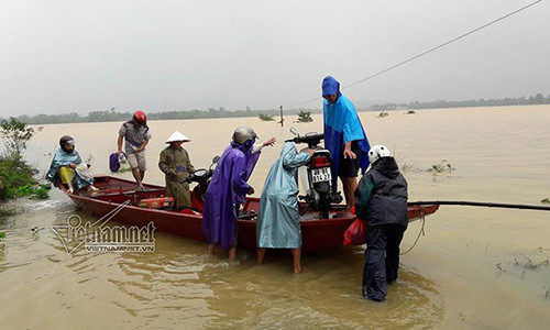Phó Chủ tịch xã Lộc Yên (huyện Hương Khê) giúp dân di dời xe máy khỏi khu vực ngập nước.